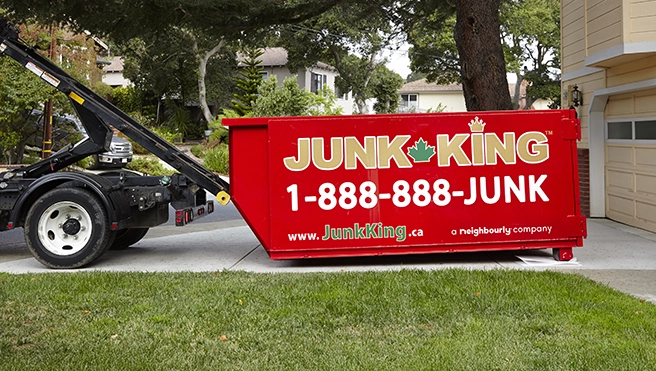 Junk King professionals dropping off a dumpster to a customer.