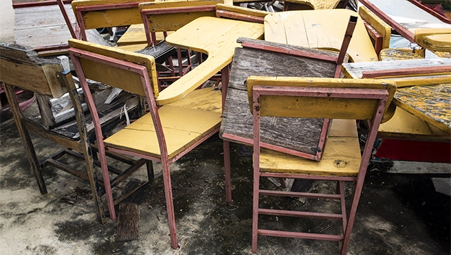 A group of old wooden school desks.