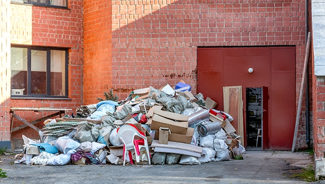 A large pile of cardboard boxes and junk sitting outside of an office building.