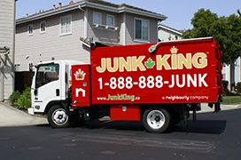 Junk King truck parked in front of a residential building.