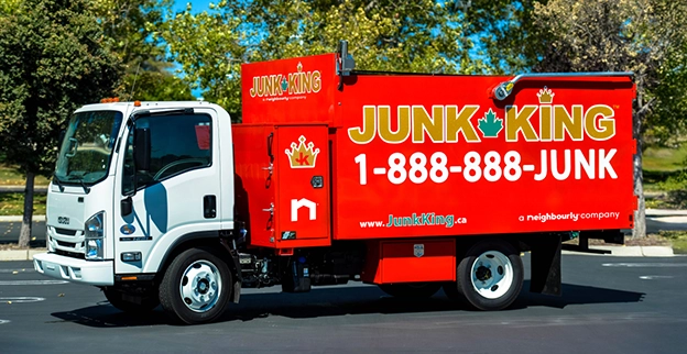 A branded Junk King dump truck parked on the street.