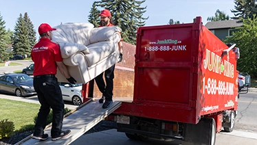 Two Junk King workers loading a truck.