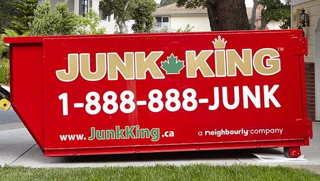 Red dumpster bin with Junk King branding on outside.