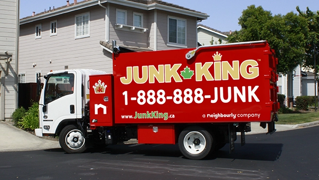 Red Junk King truck parked in front of a home.