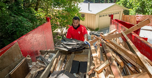 Junk King professional loading boards into the back of a truck.