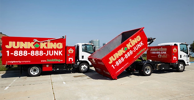 Two red Junk King dump trucks.
