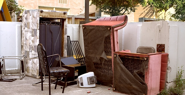 A pile of furniture sitting outside of a home.