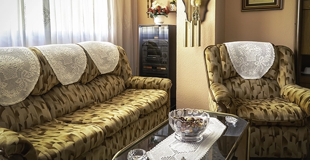 Photo of a vintage couch covered in doilies.