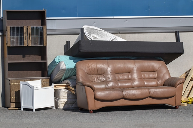 Photo of an old leather couch and bookshelf.