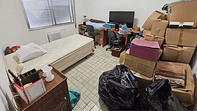 A bedroom packed up into several cardboard boxes.