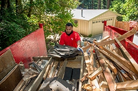 Junk King professional loading wooden boards onto a truck bed.