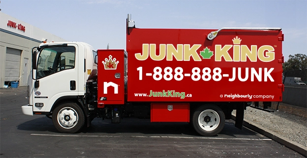 Red Junk King dump truck parked at a recycling facility.