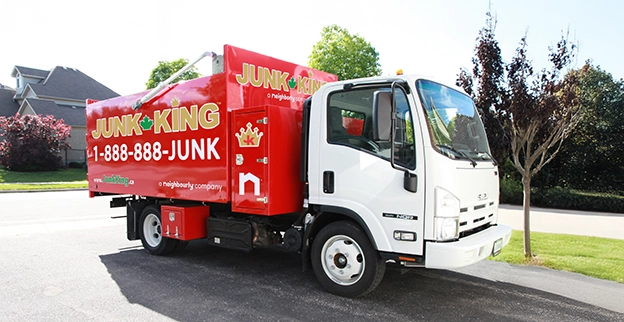 Red Junk King dump truck parked in a residential area.